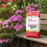 Holly-tone 4-3-4 fertilizer package with vibrant acid-loving plants like azaleas, rhododendrons, and hollies in the background, showcasing healthy growth and blooming flowers.