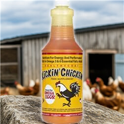 Kickinâ€™ Chicken  Qt. Bottle sitting on a rock with a chicken barn in the background