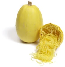 Close-up of ripe spaghetti squash fruit showing golden-yellow skin and cylindrical shape.